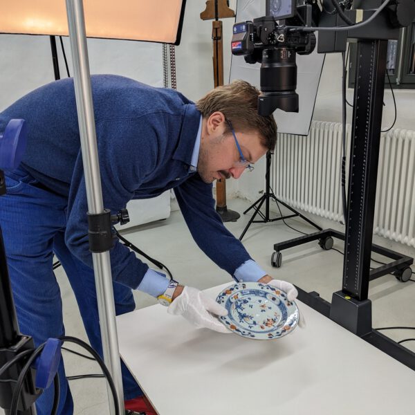 Projektleiter Constantijn Johannes Leliveld bereitet einen chinesischen Teller für Fotoaufnahmen vor. (© Museen Schloss Aschach, Foto: Josefine Glöckner)