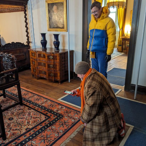 Walter Bruno Brix und Constantijn Johannes Leliveld begutachten einen Teppich im Graf-Luxburg-Museum. (© Museen Schloss Aschach, Foto: Josefine Glöckner)