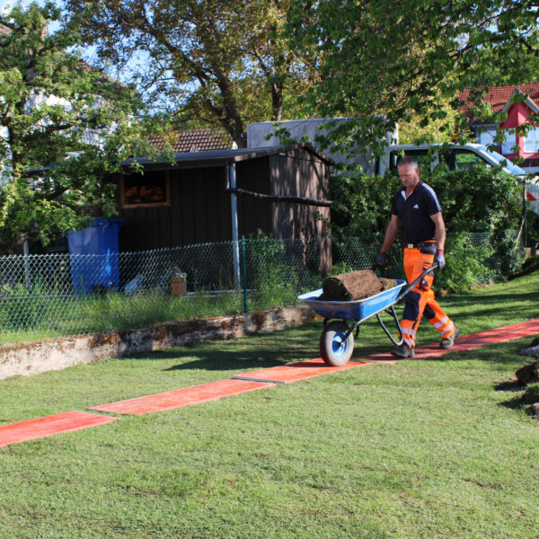 Per Schubkarre werden die Rollen an den richtigen Platz gefahren.