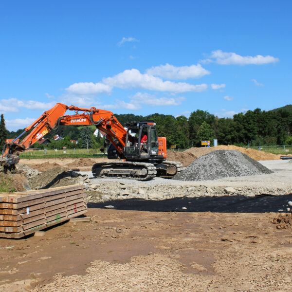 23.06.2020: Der Bagger verteilt den Schotter für den Parkplatz.