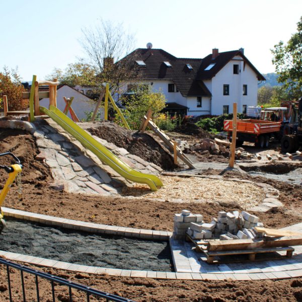 Der Weg an der Rutsche wird gepflastert.